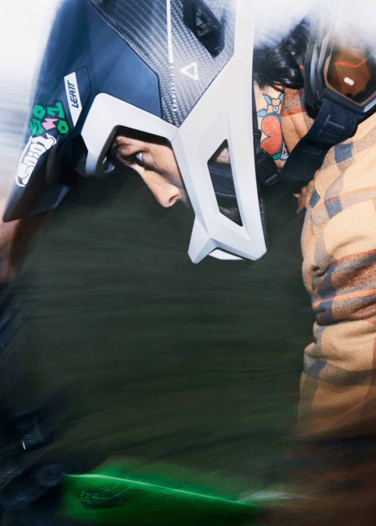 Person wearing a plaid jacket and helmet, possibly in a racing or extreme sports setting.